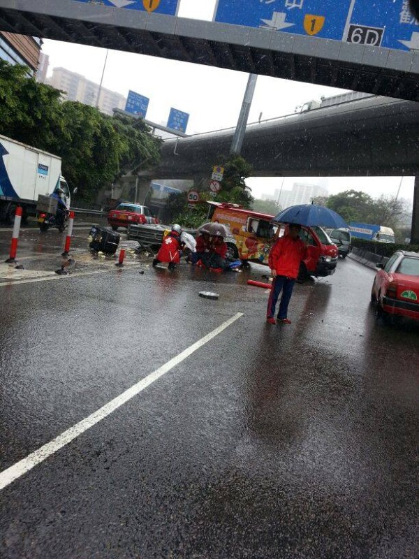 同袍為受傷消防教官撐傘擋雨。(網民細九攝)